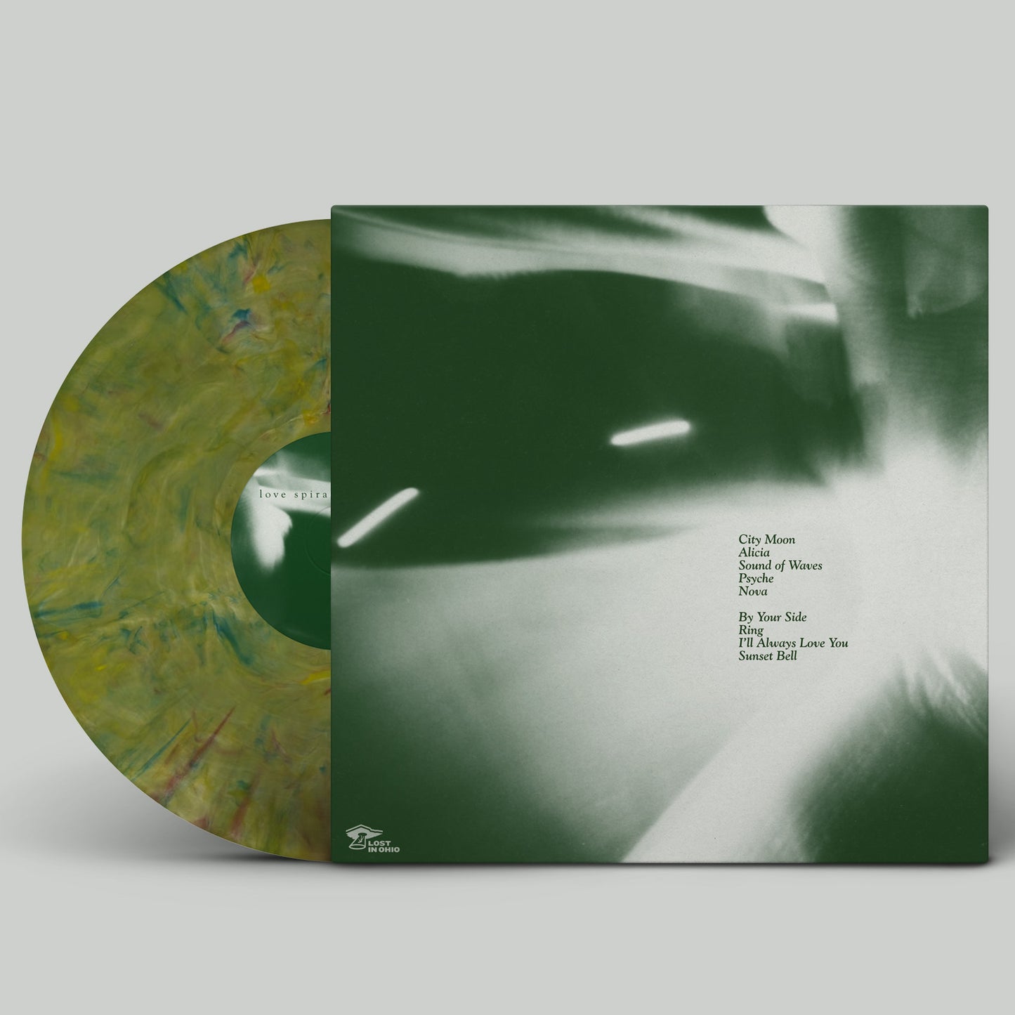 Vinyl record with green marbled design and album cover on a gray background