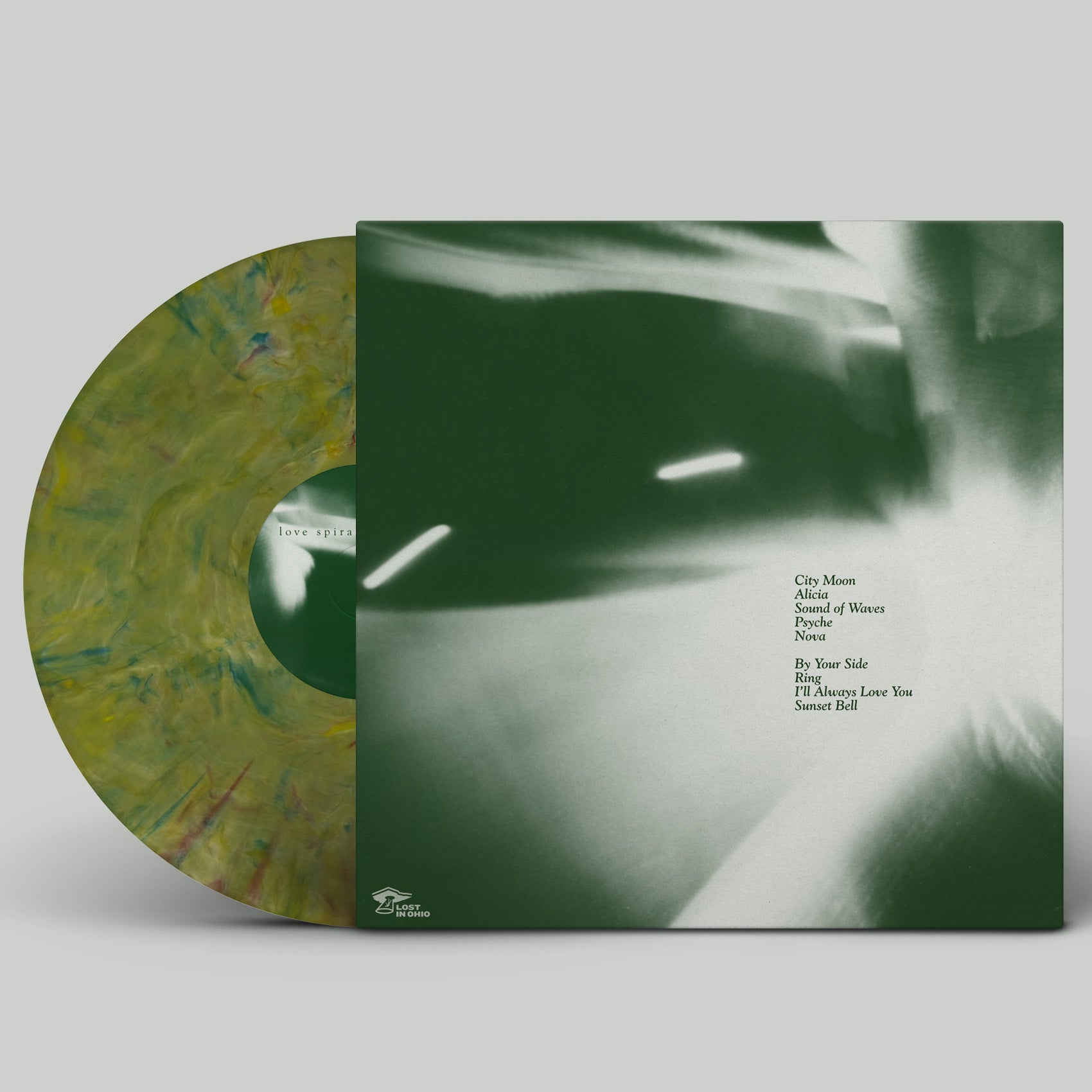 Vinyl record with green marbled design and album cover on a gray background